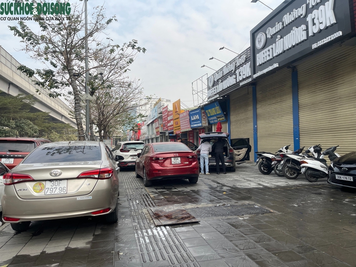 Vỉa hè đường Phạm Văn Đồng, Hà Nội bị 'xẻ thịt', thành chỗ đỗ xe, buôn bán- Ảnh 1. Vỉa hè đường Phạm Văn Đồng, Hà Nội bị 'xẻ thịt', thành chỗ đỗ xe, buôn bán- Ảnh 1.