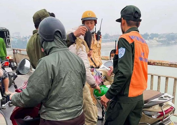 Kịp ngăn một phụ nữ đi xe máy đèo con lên cầu Chương Dương có ý định tự tử- Ảnh 1.