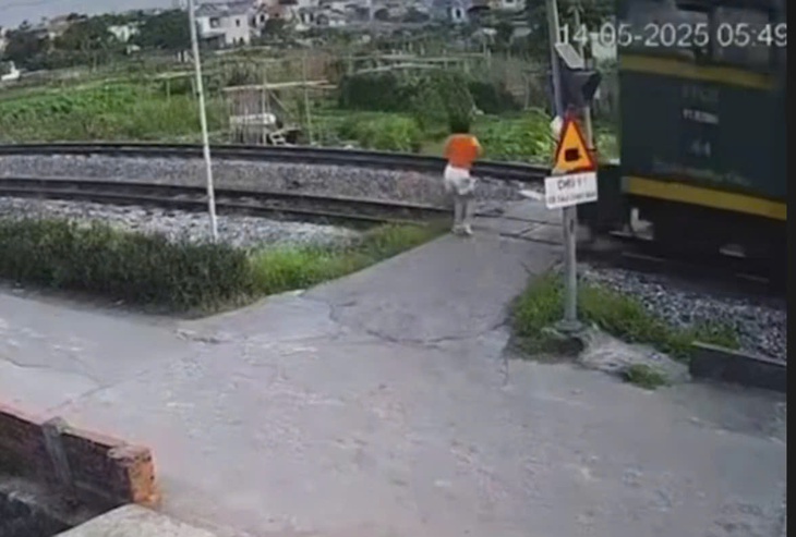 VIDEO: Băng qua đường sắt không quan sát, cô gái bị tàu hỏa hất văng- Ảnh 1.