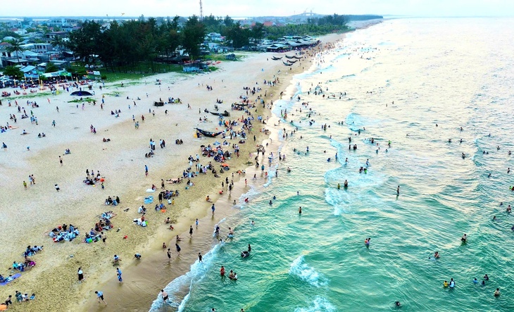 Bãi biển từng sạt lở nặng do thiên tai ở Huế đông nghịt khách dịp nghỉ lễ- Ảnh 1.