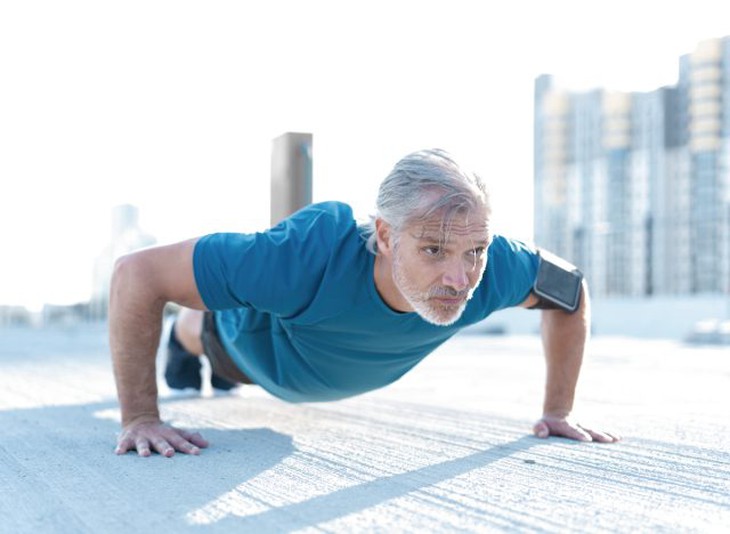 người đàn ông trưởng thành đang tập plank, thể hiện thói quen rèn luyện sức mạnh giúp làm chậm quá trình lão hóa