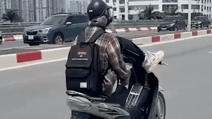 Video thanh niên dùng chân lái xe máy trên cầu vượt tại Hà Nội- Ảnh 2.