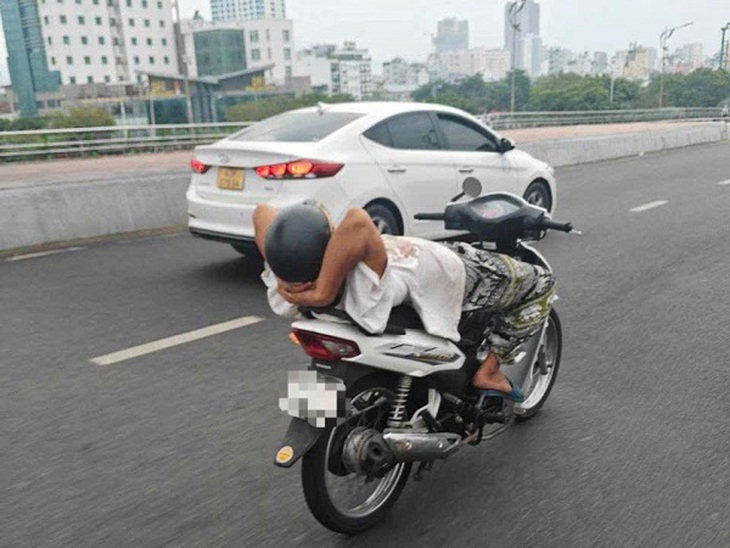Đà Nẵng: Xử lý người đàn ông điều khiển xe máy thả hai tay, nằm ngửa trên đường phố- Ảnh 1.