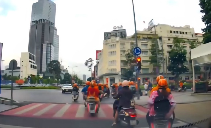 Xử phạt 10 người mặc áo cam chạy Vespa vượt đèn đỏ ở trung tâm TPHCM- Ảnh 2. Xử phạt 10 người mặc áo cam chạy Vespa vượt đèn đỏ ở trung tâm TPHCM- Ảnh 2.