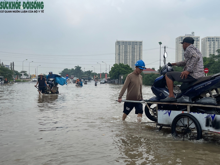 Nhiều tuyến đường ở Hà Nội vẫn ngập sâu, dịch vụ 'cõng' xe máy qua đoạn ngập đắt khách- Ảnh 2.