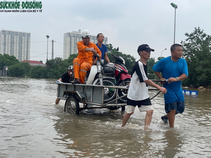 Nhiều tuyến đường ở Hà Nội vẫn ngập sâu, dịch vụ 'cõng' xe máy qua đoạn ngập đắt khách- Ảnh 3.