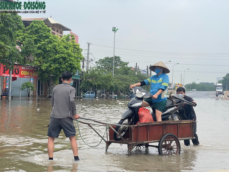 Nhiều tuyến đường ở Hà Nội vẫn ngập sâu, dịch vụ 'cõng' xe máy qua đoạn ngập đắt khách- Ảnh 5.