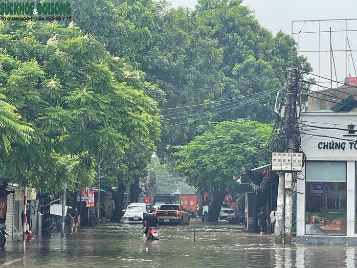 Nhiều tuyến đường ở Hà Nội vẫn ngập sâu, dịch vụ 'cõng' xe máy qua đoạn ngập đắt khách- Ảnh 9.
