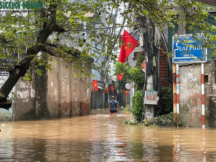 Nhiều tuyến đường ở Hà Nội vẫn ngập sâu, dịch vụ 'cõng' xe máy qua đoạn ngập đắt khách- Ảnh 10.