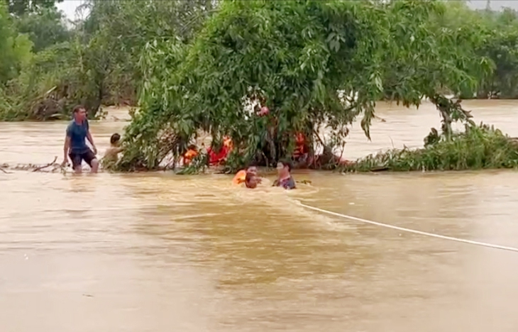 Dùng dây thừng, phao cứu sinh giải cứu 6 người mắc kẹt giữa dòng nước lũ- Ảnh 1.