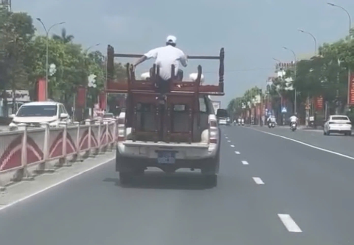Xác minh ô tô biển xanh chở bàn ghế cồng kềnh, người ngồi trên thùng khi di chuyển- Ảnh 1. Xác minh ô tô biển xanh chở bàn ghế cồng kềnh, người ngồi trên thùng khi di chuyển- Ảnh 1.