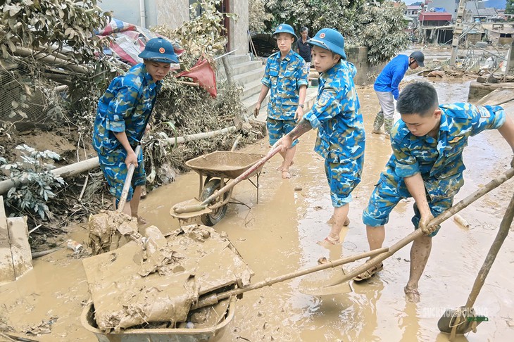 Bộ đội 'buông súng cầm xẻng' dọn bùn giúp dân khắc phục hậu quả bão số 4- Ảnh 1.