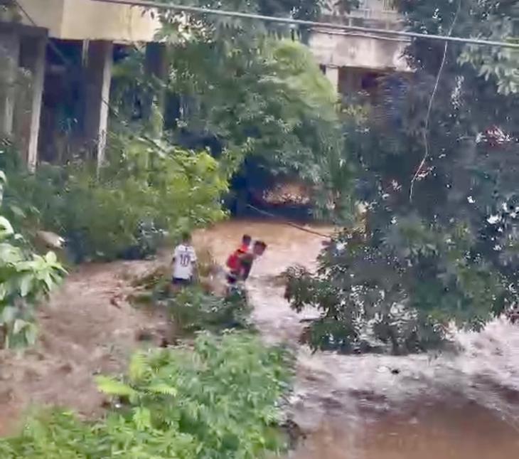 Cứu hai em nhỏ mắc kẹt giữa suối khi lũ bất ngờ tràn về- Ảnh 1.