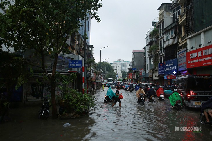 Mưa lớn kéo dài, người dân Thủ đô vượt dòng nước giữa phố - Ảnh 1.