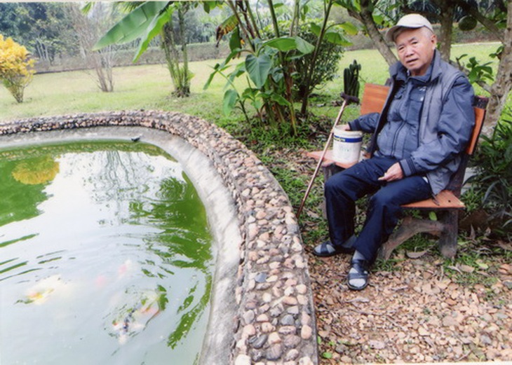 PGS.TS. Trần Đình Trọng đang cho cá Koi ăn.