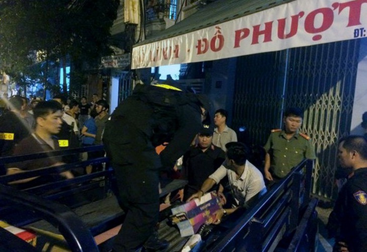 Lực lượng chức năng đưa số vũ khí thu được tại cửa hàng bán đồ lính, đồ phượt về trụ sở công an.