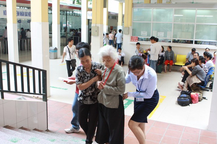 Thành viên Tổ Hỗ trợ người bệnh đang giúp đỡ bệnh nhân tại BV Việt Đức.