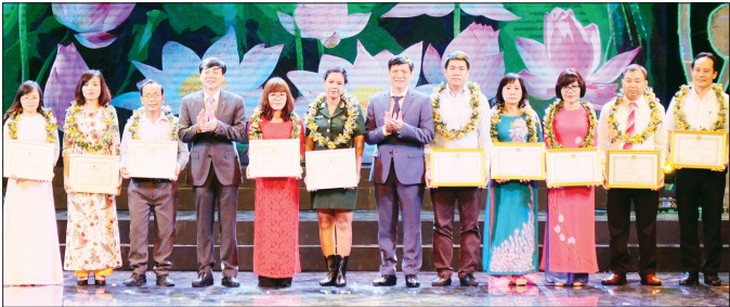 Thứ trưởng Bộ Y tế  Nguyễn Thanh Long (thứ  6 từ phải sang) và ông Hồ Quang Lợi - Phó Chủ tịch Thường trực Hội Nhà báo Việt Nam (thứ 4  từ trái sang) trao giải Ba cho tác giả và Bằng khen cho nhân vật. Ảnh: TM
