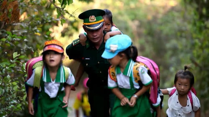 Thượng úy Trần Bình Phục cõng học trò tới lớp.