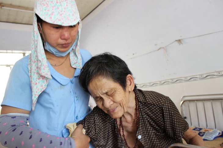 Hộ lý Phạm Thị Chính (bên trái) ân cần chăm sóc khiến nhiều cụ già trong Trung tâm xúc động bật khóc.