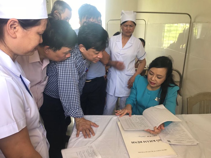 Bộ trưởng Bộ Y tế kiểm tra sổ ghi chép khám chữa bệnh tại trạm y tế xã Quỳnh Trang - huyện Quỳnh Phụ