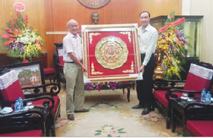Nhà giáo ưu tú Trịnh Quốc Đạt (bên trái) trao tặng phẩm của Hiệp hội Làng nghề Việt Nam cho Ủy ban Trung ương Mặt trận Tổ quốc nhân 85 năm ngày truyền thống của Mặt trận (18/11/2015).