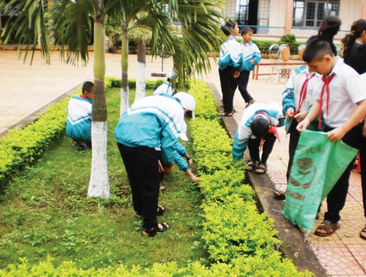 Các em học sinh tham gia thu gom rác thải làm sạch môi trường.