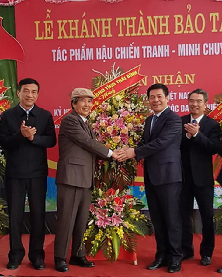 Nhà văn Minh Chuyên (thứ 2 từ trái sang) nhận hoa chúc mừng từ lãnh đạo tỉnh Thái Bình trong lễ khánh thành Bảo tàng Minh Chuyên.