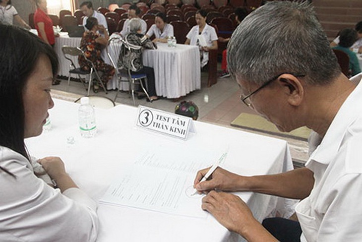 Cán bộ y tế thực hiện test tâm thần kinh cho người cao tuổi.