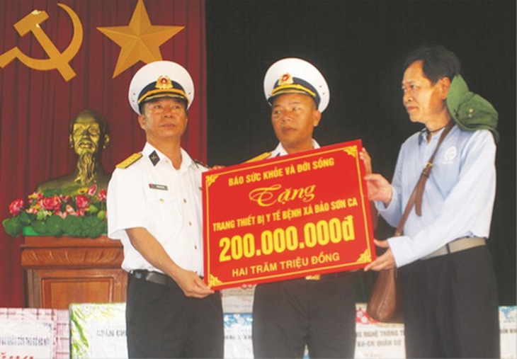 TTND.BS. Trần Sĩ Tuấn - Tổng biên tập  Báo SK&ĐS trao quà của Báo tặng Chỉ huy đảo Sơn Ca.                    Ảnh: Anh Văn.