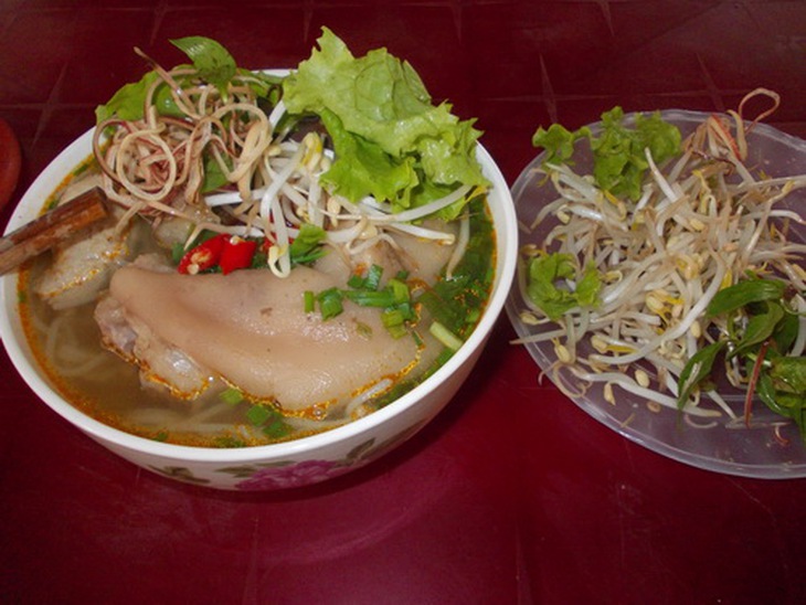 Tô bún bò giò heo đầy đủ màu sắc, hương vị ăn kèm rau sống tươi sạch.