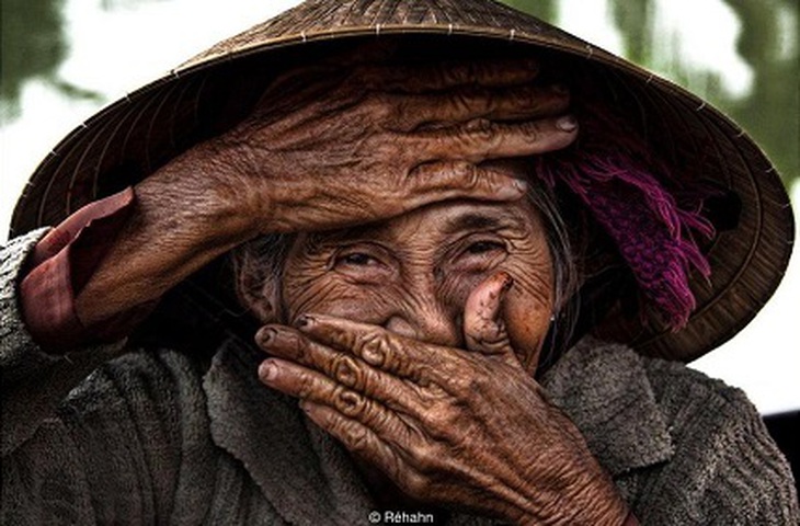Bức hình Nụ cười ẩn giấu của nhiếp ảnh gia người Pháp Réhahn chụp bà Bùi Thị Xong, 74 tuổi, người chèo thuyền lá ở Hội An.