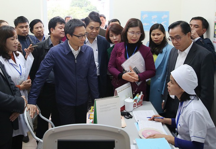 Phó Thủ tướng Vũ Đức Đam trò chuyện với cán bộ Trạm Y tế phường Tây Mỗ, quận Nam Từ Liêm, Hà Nội.  Ảnh: Đình Nam