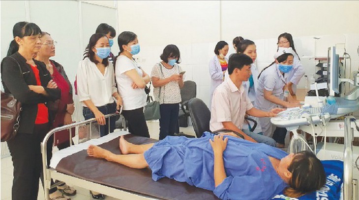 BSCKI. Trần Văn Luân - Bệnh viện Hùng Vương (người ngồi ghế) siêu âm hình thái học cho thai nhi.