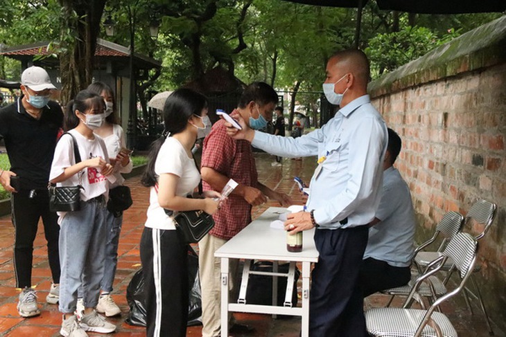 Đo nhiệt độ cho du khách để phòng ngừa dịch COVID-19.