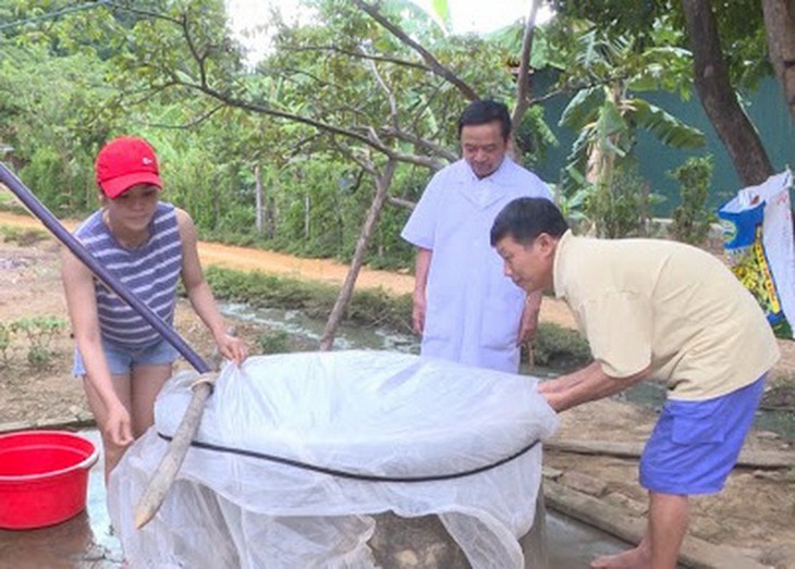 Cán bộ y tế hướng dẫn người dân cách bảo vệ nguồn nước khi mưa lũ xảy ra.