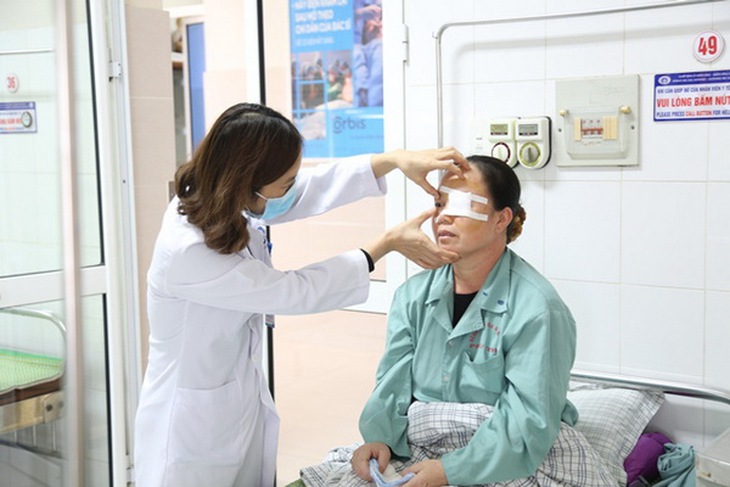 Bác sĩ kiểm tra mắt cho bệnh nhân sau phẫu thuật.