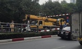 Xe cẩu 'chui' không lọt cầu vượt Thái Hà, húc đổ thanh hạn chế chiều cao, xe máy bị vạ lây