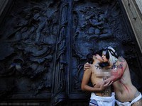 Cặp đôi đồng tính để ngực trần hôn nhau trước cửa nhà thờ