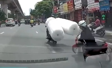 Thót tim xe máy chở hàng cồng kềnh khiến người phụ nữ ngã vào gầm ô tô