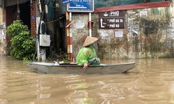 Mưa lớn, nhiều điểm úng ngập, đọng nước, dân Cầu Cốc dùng thuyền di chuyển trên phố