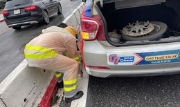 Hình ảnh đẹp về Đại úy CSGT hỗ trợ thay lốp cho xe taxi trong ngày mưa