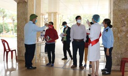 Nhân viên bệnh viện đứng trước sảnh đo thân nhiệt, sát khuẩn tay cho người dân phòng COVID-19
