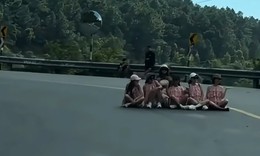 6 người phụ nữ mặc đồng phục ngồi giữa đường đèo Hải Vân chụp ảnh