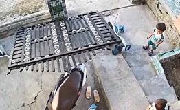 Thót tim khoảnh khắc bé trai suýt bị cổng sắt nặng đổ trúng