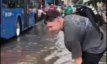 Mưa ngập đường, khách Tây hào hứng lội nước giữa trung tâm TPHCM