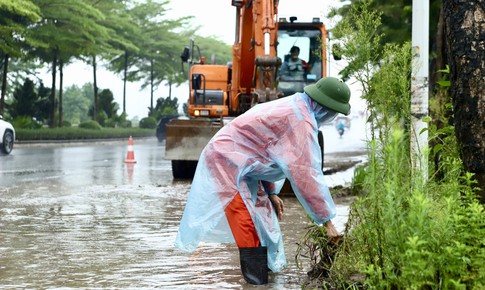 Công nhân 'đội mưa' dọn dẹp đường phố Hà Nội trước kỳ nghỉ Lễ Quốc khánh 2/9